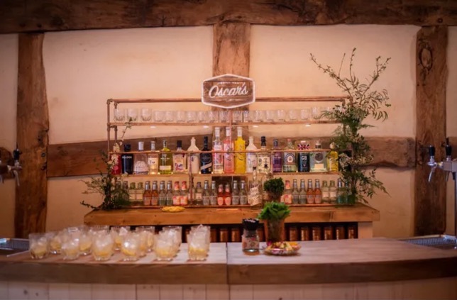 Complete mobile bar setup with rustic wooden frame, Cheers sign, and extensive spirit collection